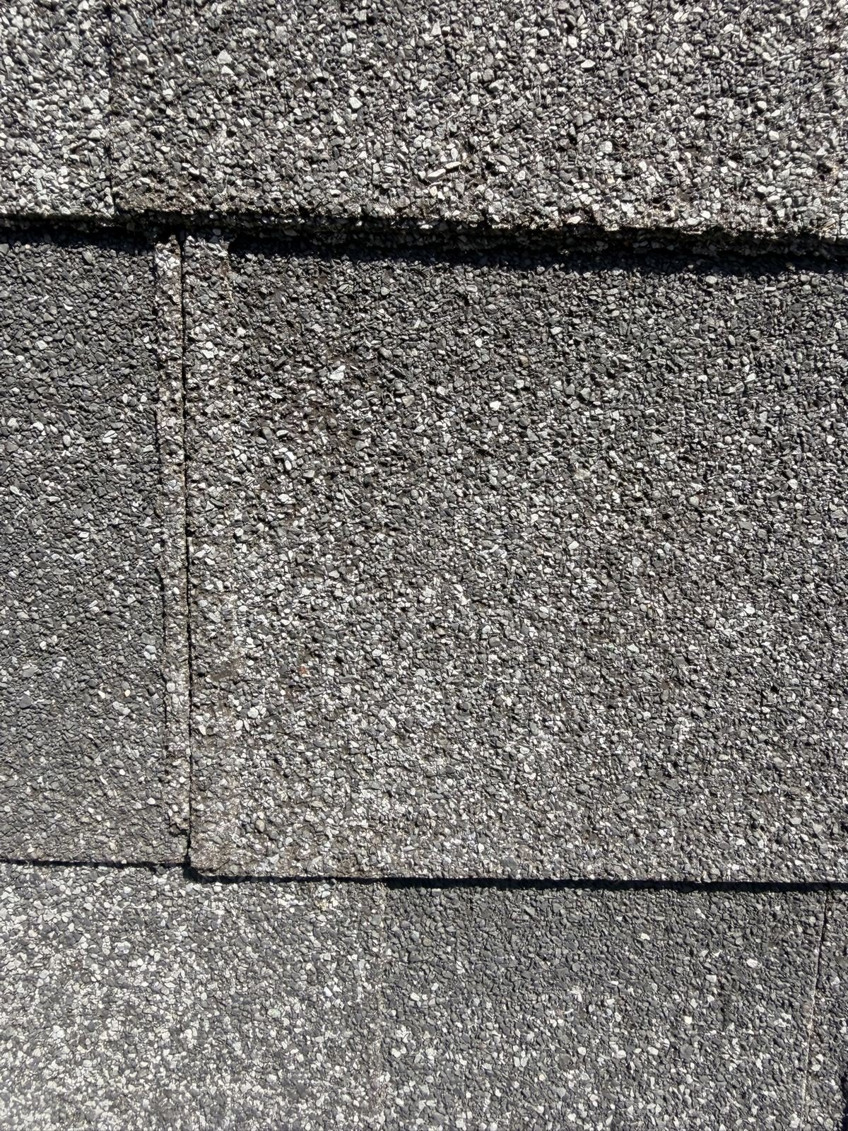 Second close-up of hail damage on a black asphalt shingle