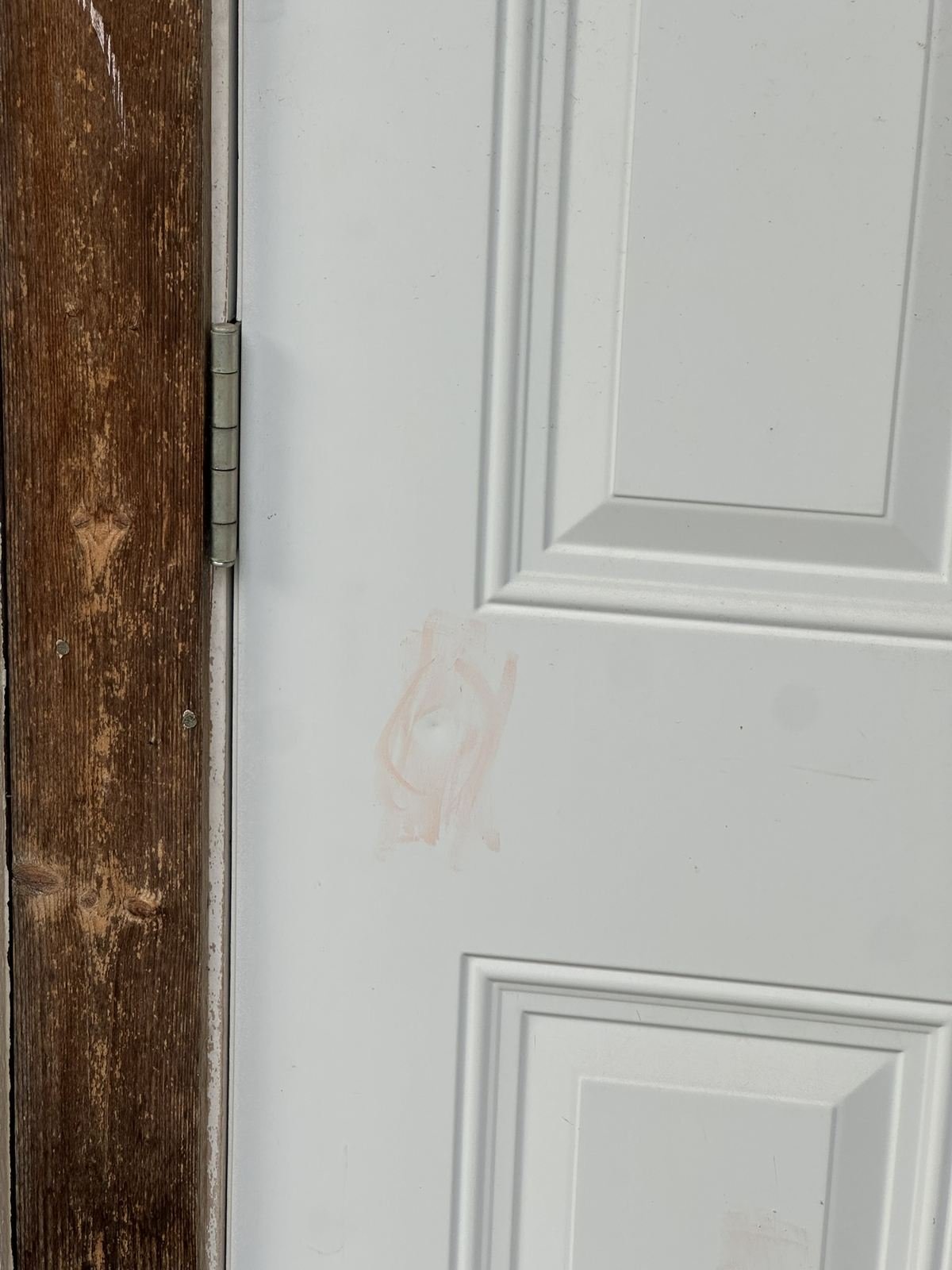 Hail hit marked in chalk near a door hinge