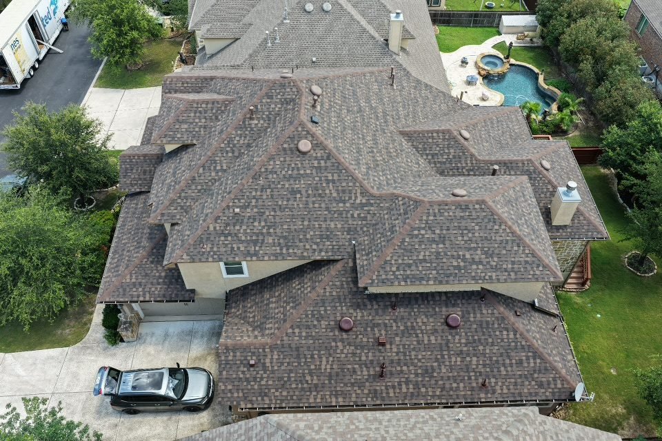 Aerial view of a completed asphalt shingle roof installation in San Antonio, TX