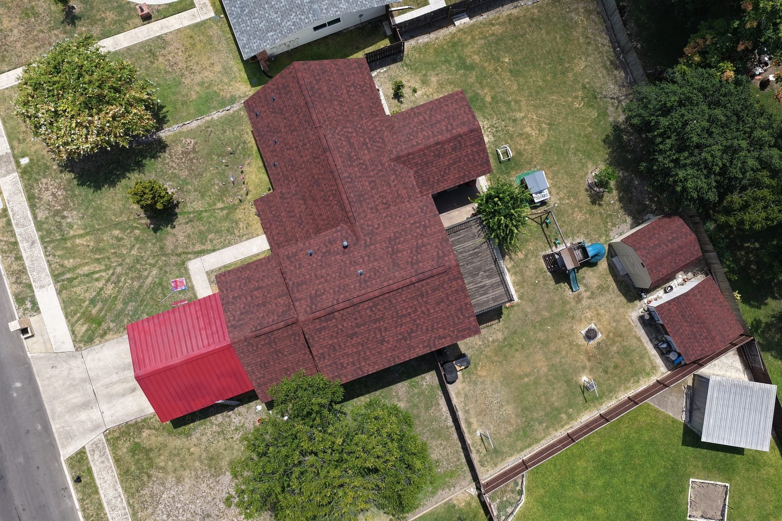 Aerial view of a completed red shingle roof installation
